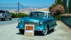 A vintage car with a for sale sign