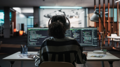 Woman working at a computer with headphones