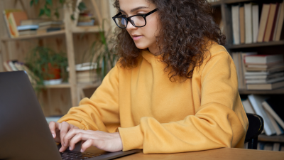 Young woman typing, researching credit card options.