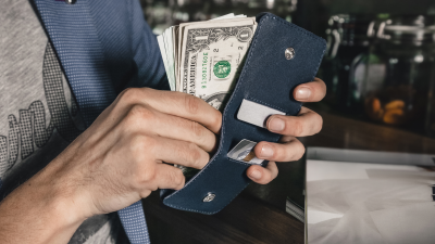 Close-up of man putting cash into wallet