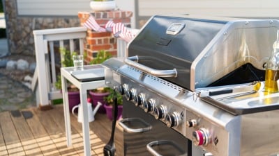 A gas grill on a patio outside.