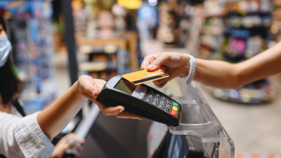 Close up of woman using tap-to-pay at grocery store