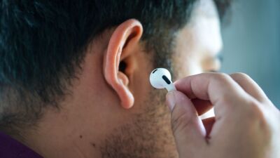 A man putting an Apple AirPod Pro into his ear