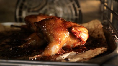 A chicken roasting in an oven. 