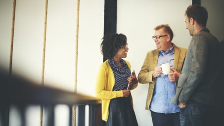 woman and two men take coffee break at work