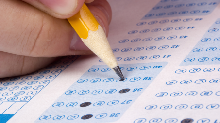 close-up of a person filling in a standardized test sheet