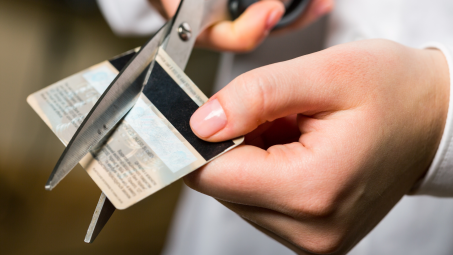 Closeup of hands cutting credit card