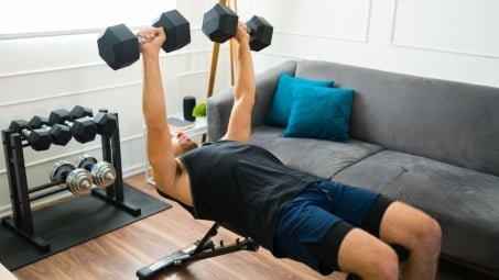 guy benching in his living room