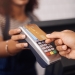 woman handing card to cashier 