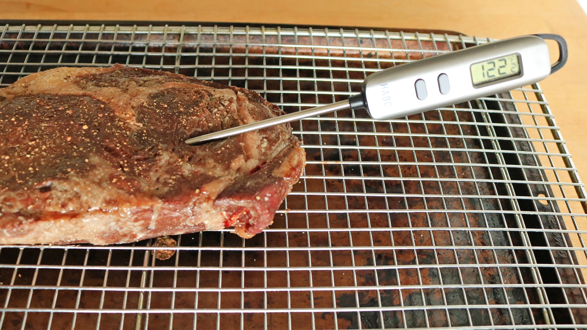 A thermometer in a steak reads 122 degrees.