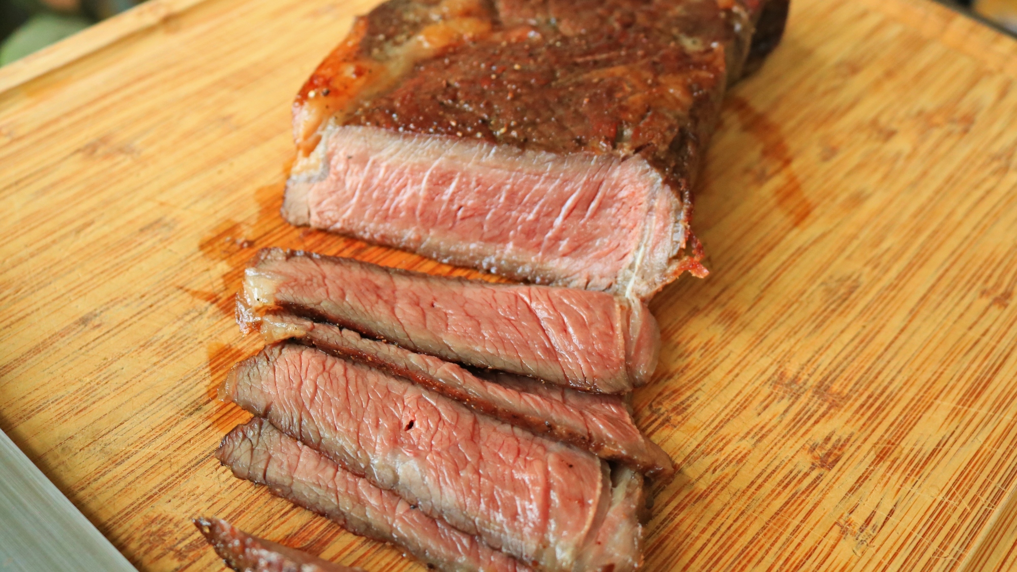 Sliced steak on a cutting board.