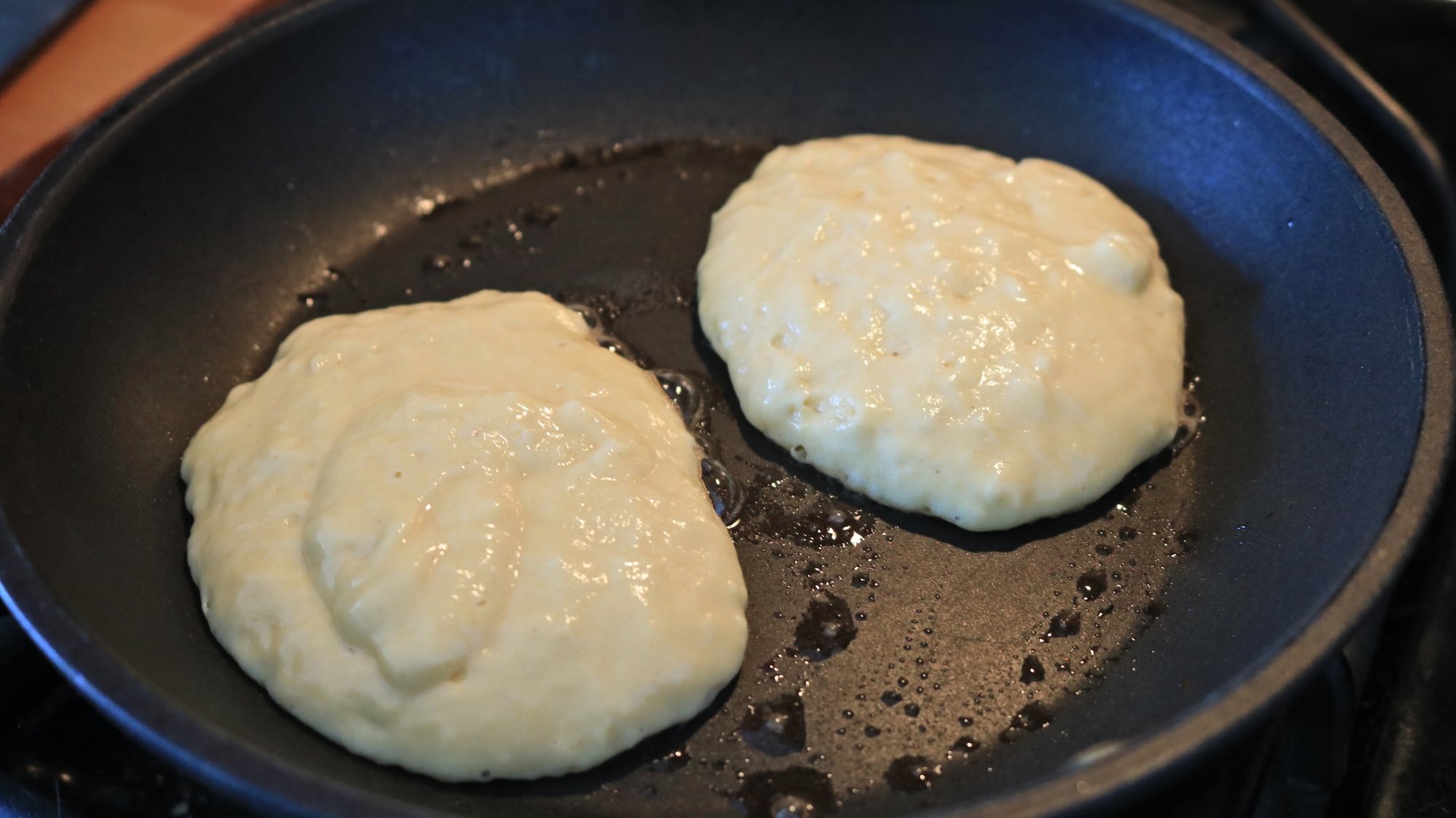 Two pancakes in a frying pan.